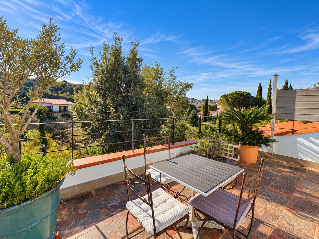 Table bistrot sur la terrasse, à côté d'un olivier en pot