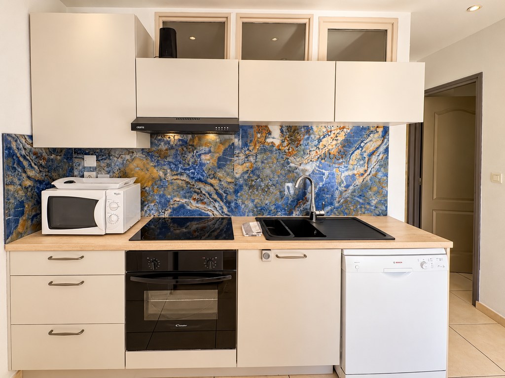 Cuisine avec four, plaque de cuisson, micro-ondes et lave-vaisselle