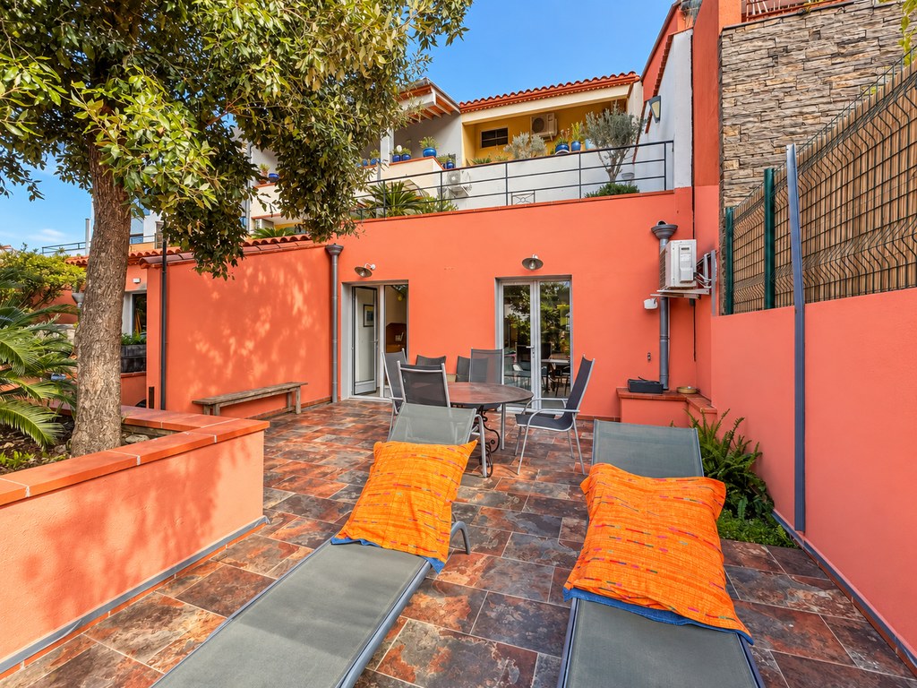 Terrasse avec chaises longues, table et arbre